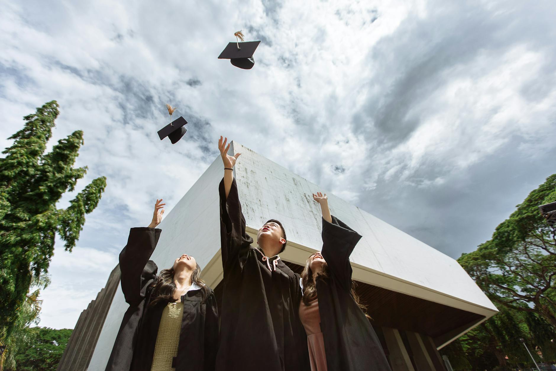 students throwing their mortarboards